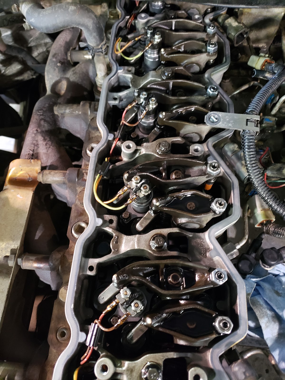 Close-up of engine work in progress with the valve cover removed at Oil Haus Plus