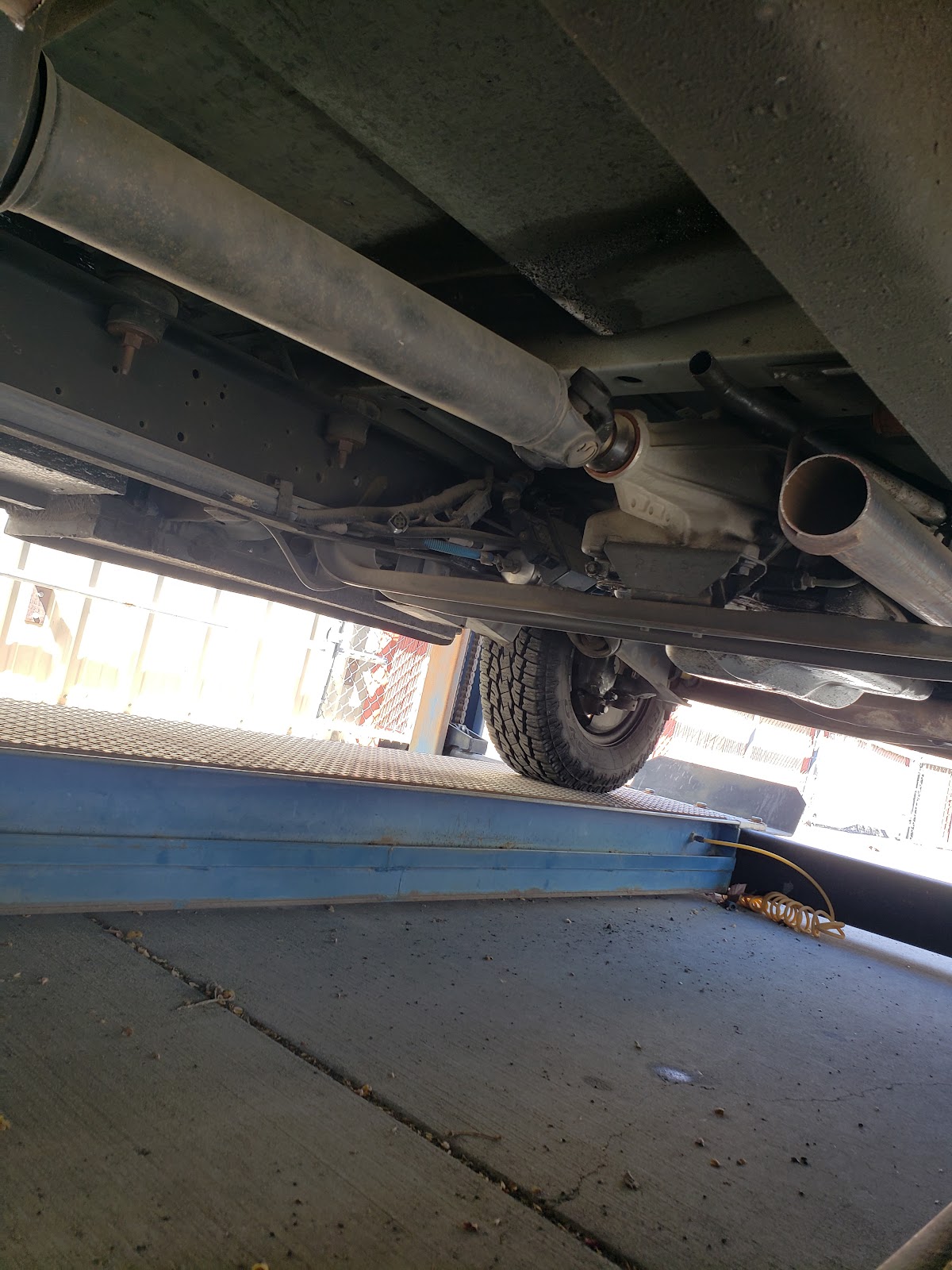 A vehicle up on the alignment rack inside the Oil Haus Plus service bay